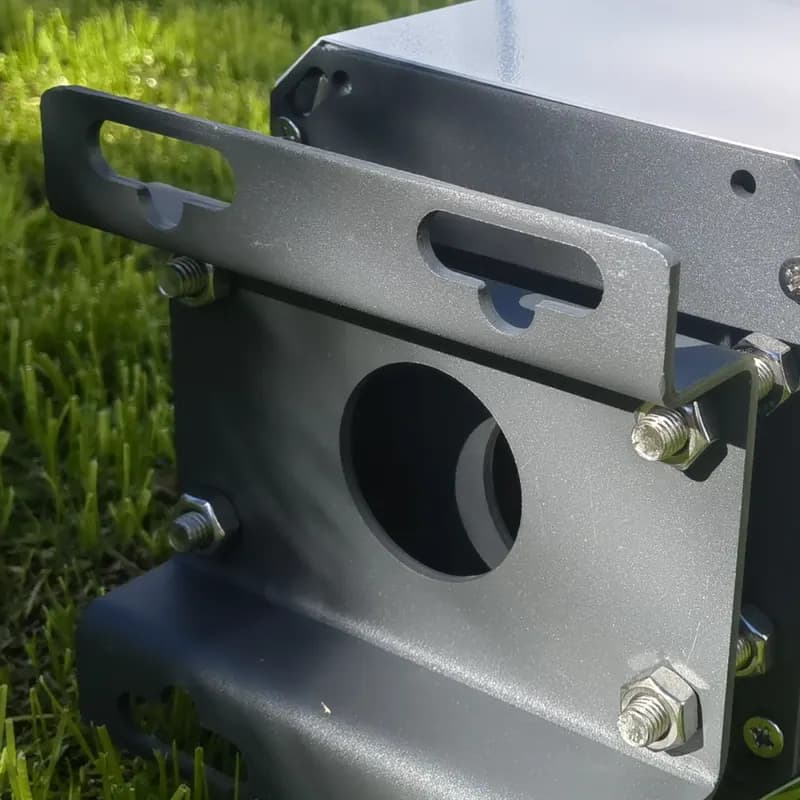 A powder-coated aluminium beam and its steel mounting bracket lying on grass before installation