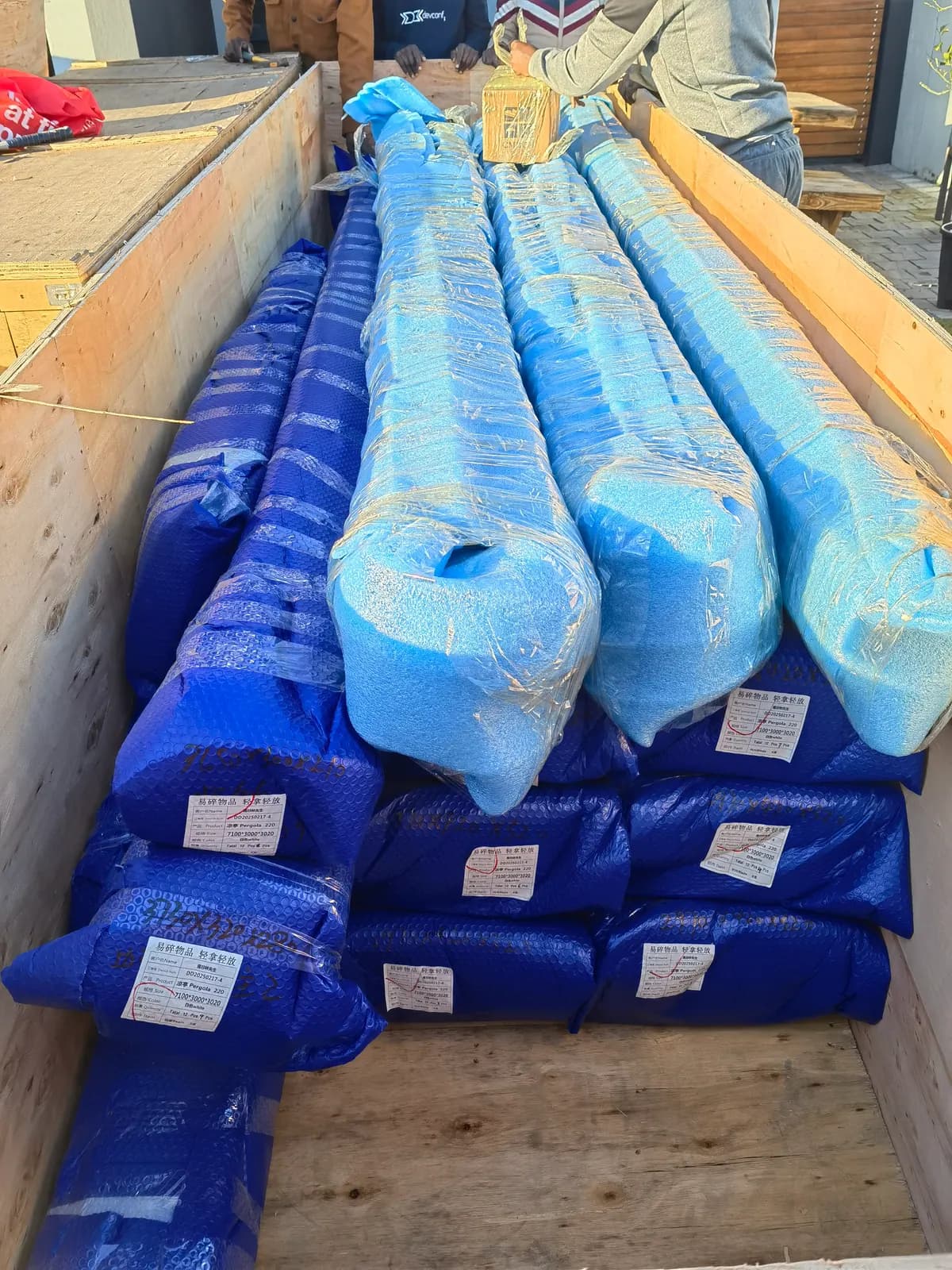 Louvre blades wrapped in blue protective film packed in a crate