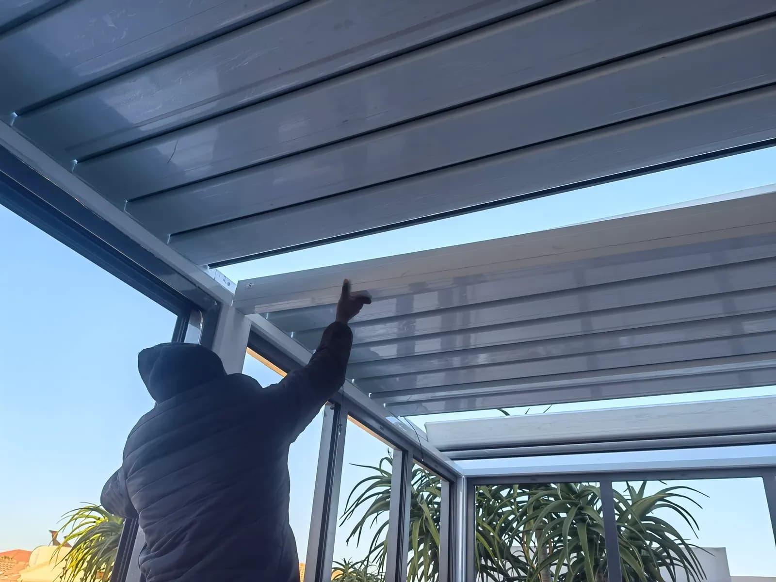 An installer fitting louvre blades into the frame from below
