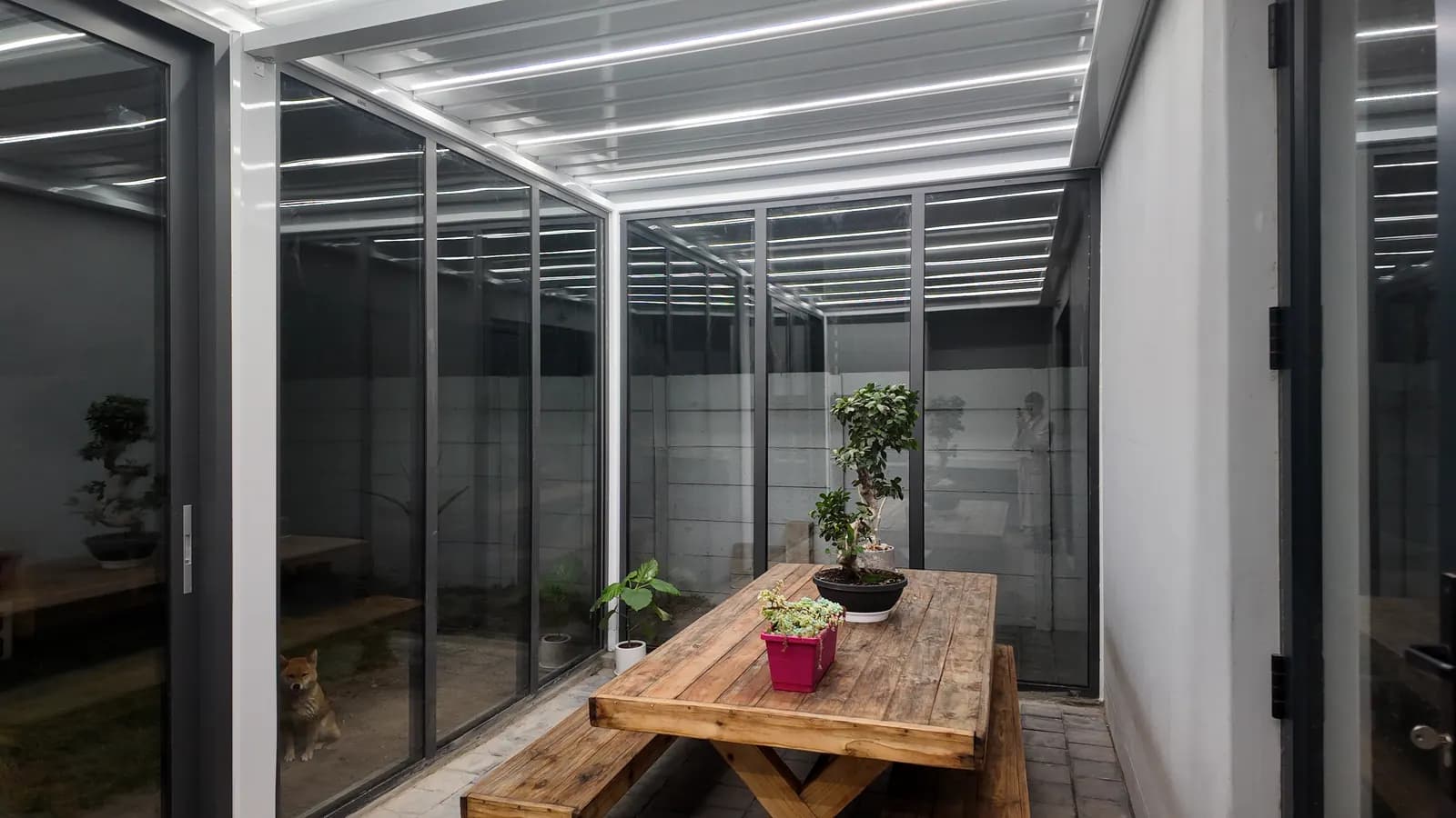 The finished room at night with the LED louvres reflected in the glass doors