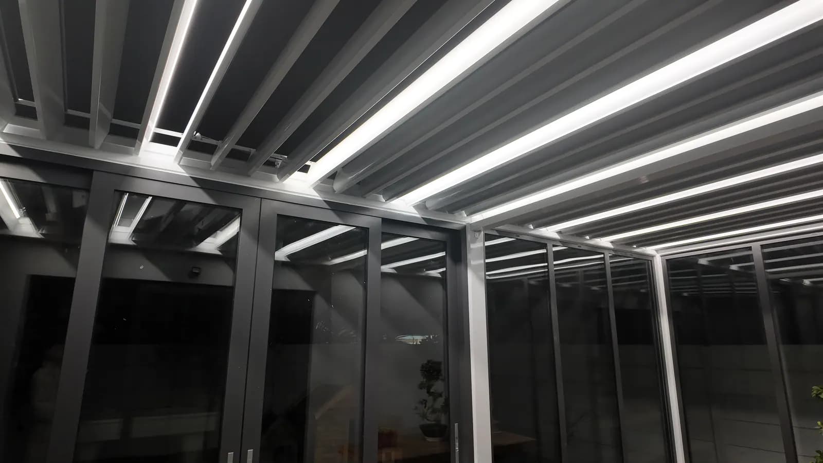 Louvres tilted open at night with LED lines along each blade